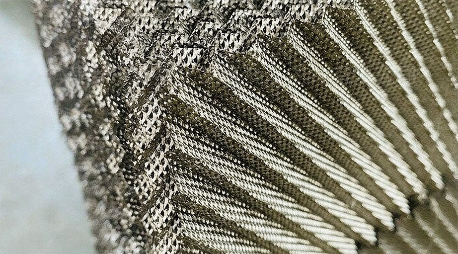 Cutaway diagram of perforated corrugated plates showing reversed corrugation angles and flow channels